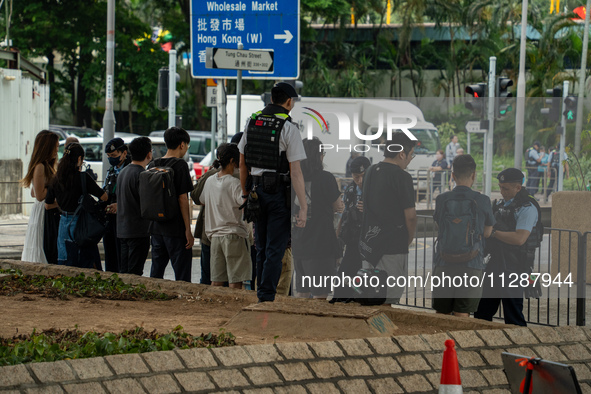 Police officers are checking the bags of people outside the courthouse where the verdict of the trial of the 47 Pro-democracy figures is bei...