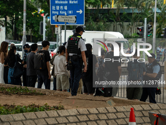 Police officers are checking the bags of people outside the courthouse where the verdict of the trial of the 47 Pro-democracy figures is bei...