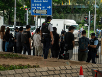 Police officers are checking the bags of people outside the courthouse where the verdict of the trial of the 47 Pro-democracy figures is bei...