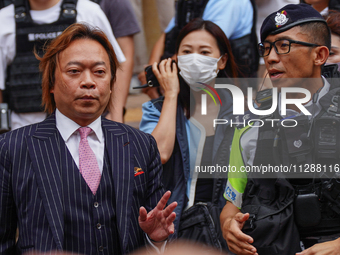 Lawrence Lau (left) is leaving the court building after being acquitted, in Hong Kong, China, on May 30, 2024. (