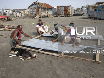 Men are repairing their damaged shop after Cyclone Remal's landfall in Patuakhali, Bangladesh, on May 29, 2024. Cyclone Remal, which made la...