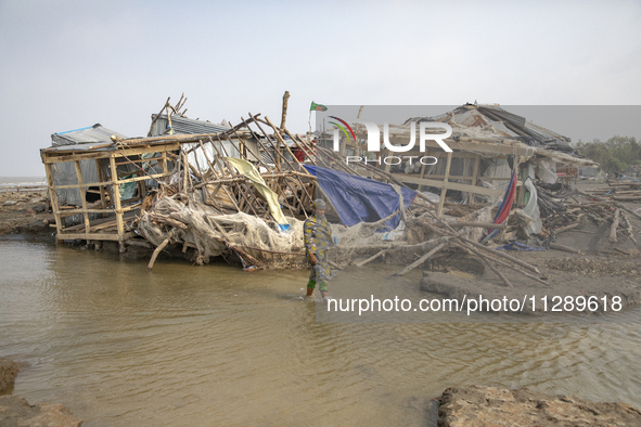 A woman is walking past a damaged shop after Cyclone Remal's landfall in Patuakhali, Bangladesh, on May 29, 2024. Cyclone Remal, which is ma...