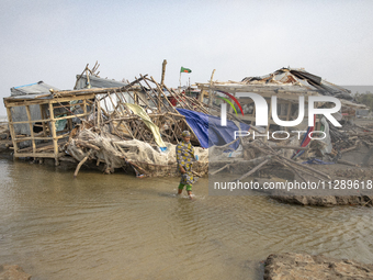 A woman is walking past a damaged shop after Cyclone Remal's landfall in Patuakhali, Bangladesh, on May 29, 2024. Cyclone Remal, which is ma...