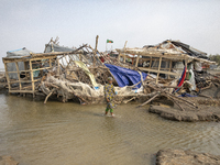 A woman is walking past a damaged shop after Cyclone Remal's landfall in Patuakhali, Bangladesh, on May 29, 2024. Cyclone Remal, which is ma...