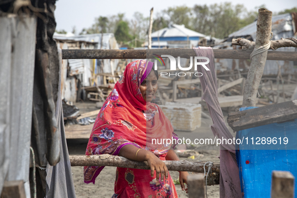 A woman is standing at a damaged shop after Cyclone Remal's landfall in Patuakhali, Bangladesh, on May 29, 2024. Cyclone Remal, which is mak...