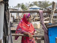 A woman is standing at a damaged shop after Cyclone Remal's landfall in Patuakhali, Bangladesh, on May 29, 2024. Cyclone Remal, which is mak...