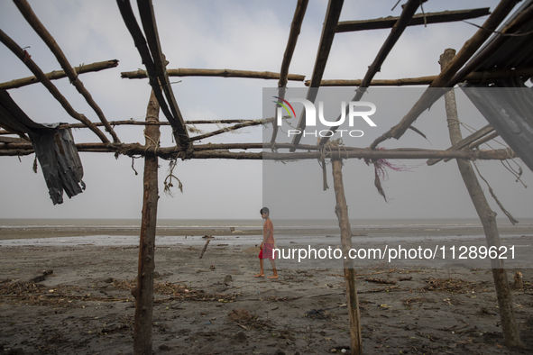 A boy is walking past a damaged shop after Cyclone Remal's landfall in Patuakhali, Bangladesh, on May 29, 2024. Cyclone Remal, which is maki...