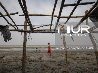 A boy is walking past a damaged shop after Cyclone Remal's landfall in Patuakhali, Bangladesh, on May 29, 2024. Cyclone Remal, which is maki...