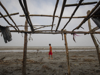 A boy is walking past a damaged shop after Cyclone Remal's landfall in Patuakhali, Bangladesh, on May 29, 2024. Cyclone Remal, which is maki...