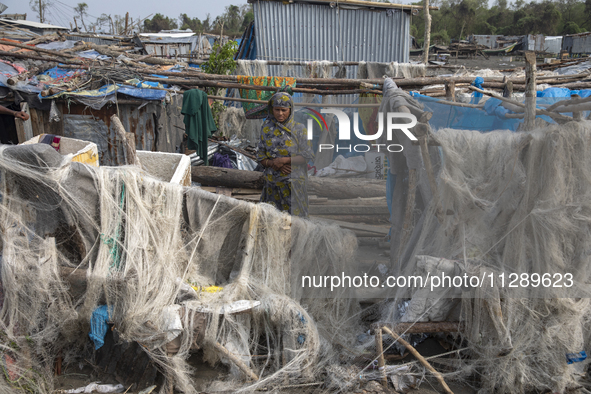 A woman is standing at a damaged house after Cyclone Remal's landfall in Patuakhali, Bangladesh, on May 29, 2024. Cyclone Remal, which is ma...