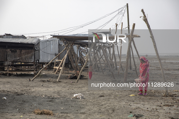 A woman and a child are walking past a damaged shop after Cyclone Remal's landfall in Patuakhali, Bangladesh, on May 29, 2024. Cyclone Remal...