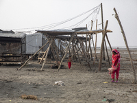 A woman and a child are walking past a damaged shop after Cyclone Remal's landfall in Patuakhali, Bangladesh, on May 29, 2024. Cyclone Remal...