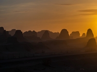 The Yadan landform landscape of the Devil City scenic area in the desert Gobi is being seen at sunset after strong winds in Karamay, China,...