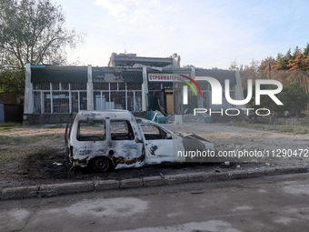 A burnt-out car is being seen outside a building damaged by the overnight Russian missile attack in the Novobavarskyi district of Kharkiv, n...