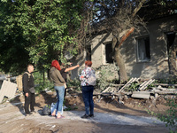 People are standing by a house damaged by the overnight Russian missile attack in the Novobavarskyi district of Kharkiv, Ukraine, on May 31,...