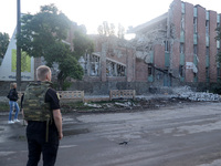 A law enforcer in a bulletproof vest is facing a building damaged by the overnight Russian missile attack in the Novobavarskyi district of K...