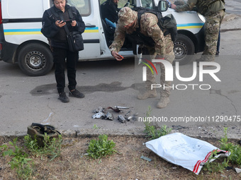 A law enforcer is taking pictures of missile debris after the overnight Russian missile attack in the Novobavarskyi district of Kharkiv, nor...