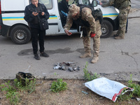 A law enforcer is taking pictures of missile debris after the overnight Russian missile attack in the Novobavarskyi district of Kharkiv, nor...