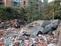 Cars are being crushed by the rubble outside a block of flats damaged by the overnight Russian missile attack in the Novobavarskyi district...