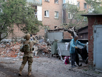 A law enforcer is taking pictures of a block of flats after the overnight Russian missile attack in the Novobavarskyi district of Kharkiv, n...