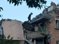 A rescuer is removing the rubble at a block of flats damaged by the overnight Russian missile attack in the Novobavarskyi district of Kharki...