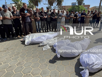 Mourners are gathering next to the bodies of Palestinians killed in an Israeli strike, amid the ongoing conflict between Israel and the Pale...