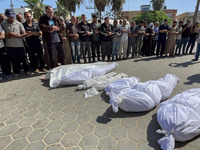 Mourners are gathering next to the bodies of Palestinians killed in an Israeli strike, amid the ongoing conflict between Israel and the Pale...