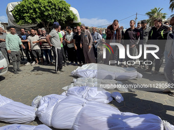 Mourners are gathering next to the bodies of Palestinians killed in an Israeli strike, amid the ongoing conflict between Israel and the Pale...