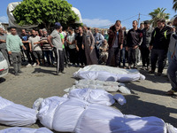 Mourners are gathering next to the bodies of Palestinians killed in an Israeli strike, amid the ongoing conflict between Israel and the Pale...