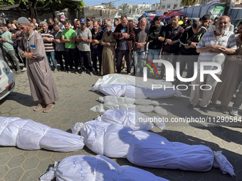 Mourners are gathering next to the bodies of Palestinians killed in an Israeli strike, amid the ongoing conflict between Israel and the Pale...