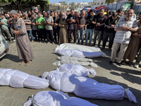 Mourners are gathering next to the bodies of Palestinians killed in an Israeli strike, amid the ongoing conflict between Israel and the Pale...