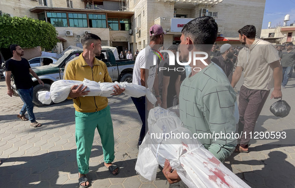 Mourners are gathering next to the bodies of Palestinians killed in an Israeli strike, amid the ongoing conflict between Israel and the Pale...