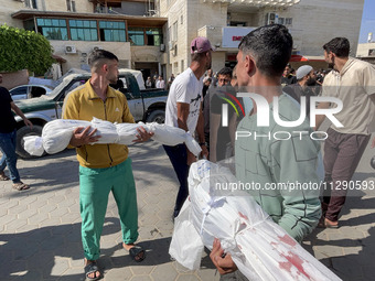 Mourners are gathering next to the bodies of Palestinians killed in an Israeli strike, amid the ongoing conflict between Israel and the Pale...