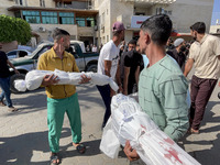 Mourners are gathering next to the bodies of Palestinians killed in an Israeli strike, amid the ongoing conflict between Israel and the Pale...