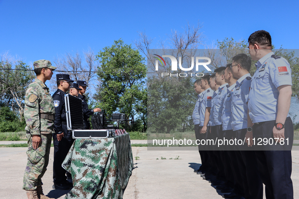 Border police are explaining the types of drones in Altay, Xinjiang province, China, on May 31, 2024. 