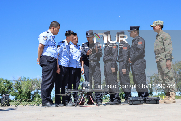 A border police officer is explaining the precautions during a drone flight in Altay, Xinjiang province, China, on May 31, 2024. 