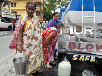 Residents are queuing up to collect drinking water provided by PHE water supply tanks in Siliguri, India, on May 31, 2024. The entire area,...