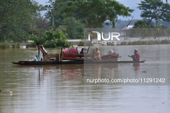 Villagers are taking their belongings on a boat to a safer place after the landfall of cyclone 'Remal' in Nagaon district of Assam, India, o...