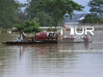 Villagers are taking their belongings on a boat to a safer place after the landfall of cyclone 'Remal' in Nagaon district of Assam, India, o...