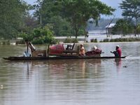 Villagers are taking their belongings on a boat to a safer place after the landfall of cyclone 'Remal' in Nagaon district of Assam, India, o...