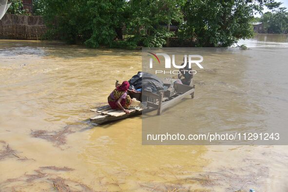 Villagers are taking their belongings on a boat to a safer place after the landfall of cyclone 'Remal' in Nagaon district of Assam, India, o...