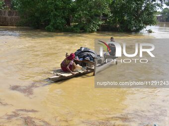 Villagers are taking their belongings on a boat to a safer place after the landfall of cyclone 'Remal' in Nagaon district of Assam, India, o...