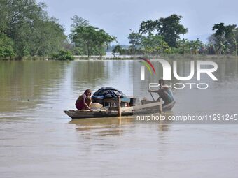 Villagers are taking their belongings on a boat to a safer place after the landfall of cyclone 'Remal' in Nagaon district of Assam, India, o...