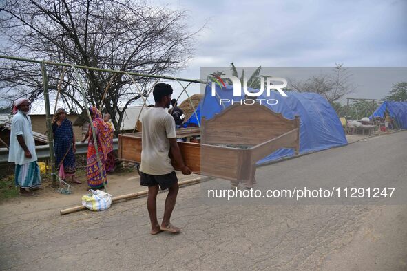 Flood-affected villagers are staying in their makeshift camp on a road after the landfall of cyclone 'Remal' in Nagaon district of Assam, In...