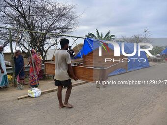 Flood-affected villagers are staying in their makeshift camp on a road after the landfall of cyclone 'Remal' in Nagaon district of Assam, In...