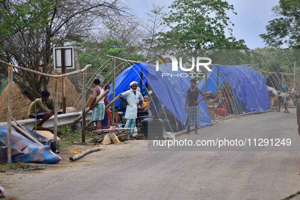 Flood-affected villagers are staying in their makeshift camp on a road after the landfall of cyclone 'Remal' in Nagaon district of Assam, In...