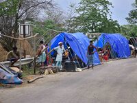 Flood-affected villagers are staying in their makeshift camp on a road after the landfall of cyclone 'Remal' in Nagaon district of Assam, In...