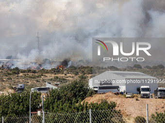 Smoke is being seen behind an industrial building in Limassol, Cyprus, on May 31, 2024. Some buildings are being endangered after a fire bre...