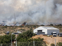 Smoke is being seen behind an industrial building in Limassol, Cyprus, on May 31, 2024. Some buildings are being endangered after a fire bre...