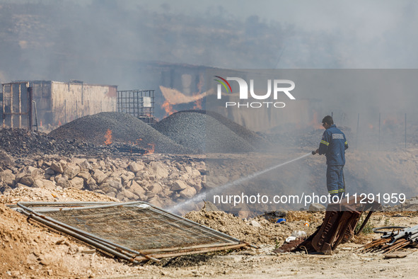 A firefighter is trying to put out the fire in Limassol, Cyprus, on May 31, 2024. Some buildings are in danger after a fire breaks out in th...